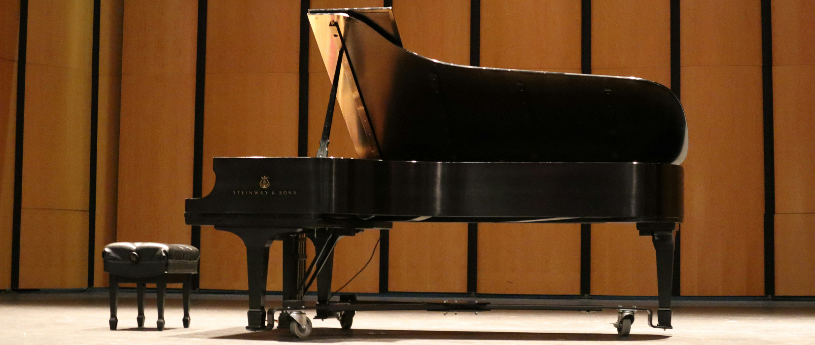 grand piano close up elegant keys warm concert hall lighting