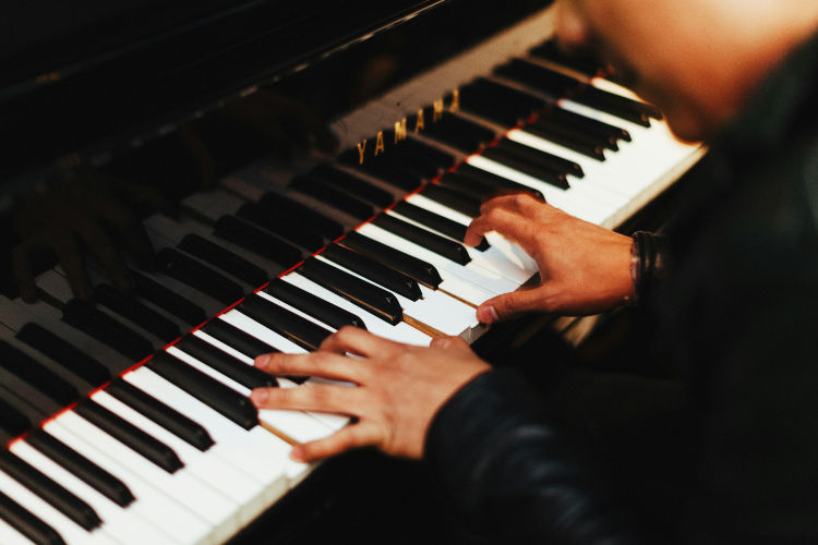 grand piano close-up elegant keys, warm studio lighting, classical music aesthetic, dark moody tones