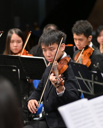 conductor raising baton before a full symphony orchestra on a grand stage, dramatic spotlight, cinem