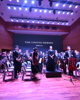 orchestra bowing after a gala performance in a packed concert hall, audience applause, warm golden l
